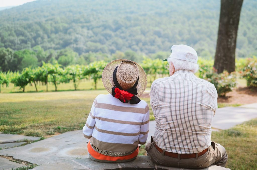 Pareja de personas mayores sentada mirando el paisaje, simbolizando el acompañamiento del proyecto HappyAgeing